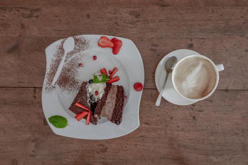 a plate with a piece of cake and a cup of coffee at Wrzos & Belvedere in Kudowa-Zdrój