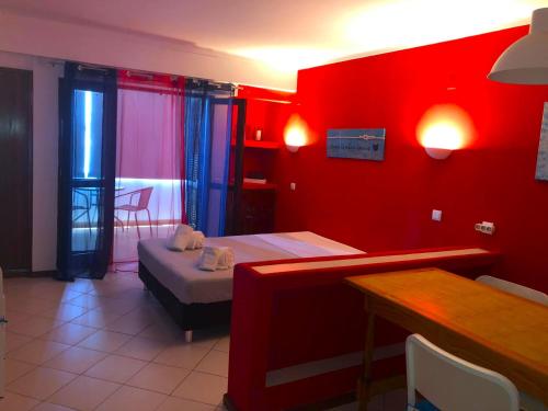 um quarto com uma parede vermelha com uma cama e uma mesa em XAVILLA 8 em Albufeira