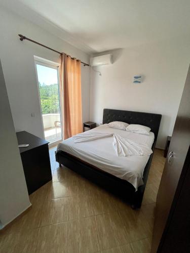 a bedroom with a bed and a large window at Bora Lindi Ulcinj apartments in Ulcinj