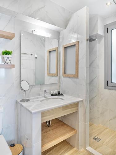 a white bathroom with a sink and a mirror at Acropolis City Life BH in Athens