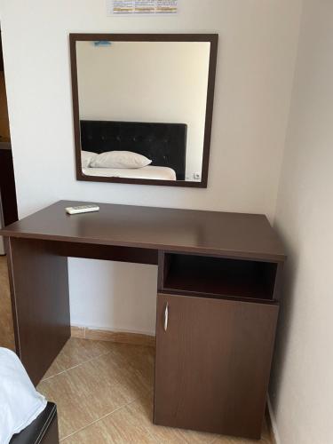 a brown desk with a mirror on a wall at Bora Lindi Ulcinj apartments in Ulcinj