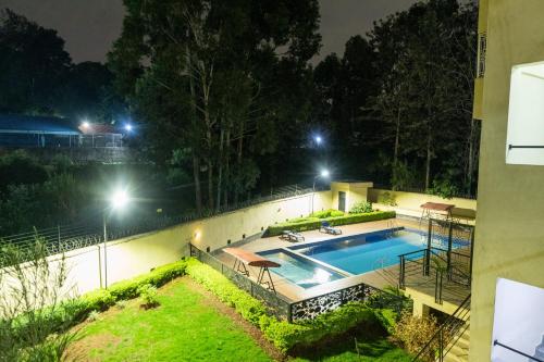 a swimming pool in a yard at night at Cozy Penthouse by Hush in Nairobi