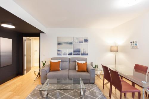 uma sala de estar com um sofá e uma mesa em FLH Praça Comércio Artistic Flat with Balcony em Lisboa