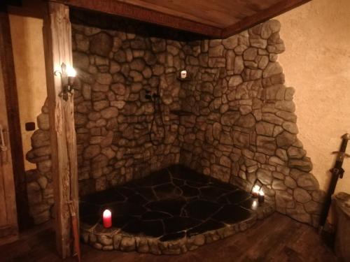 a stone fireplace with two candles in a room at El descanso de Odín ¡Una auténtica posada vikinga! in Mataelpino