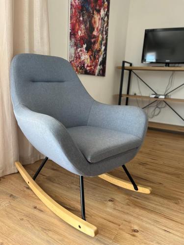 a blue chair with wooden legs in a room at Apartments Mrdak in Bar