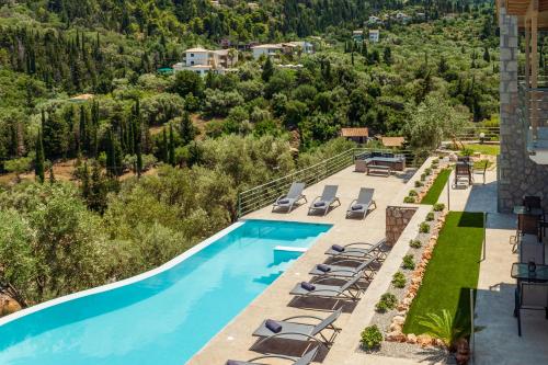 an aerial view of a pool with lounge chairs and a resort at Mylos Mountain Villas- Villa Giorgio in Agios Nikitas