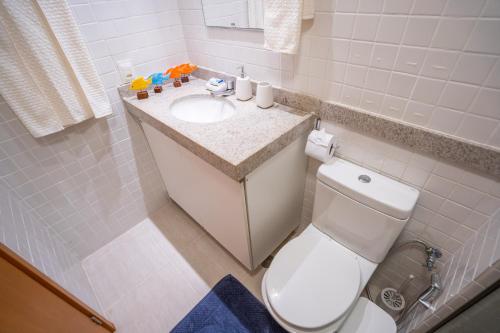 a bathroom with a white toilet and a sink at Flat em Porto de Galinhas com Piscina Exclusiva in Porto De Galinhas