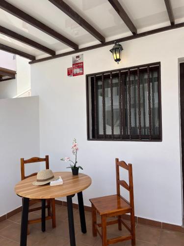 a table and chairs in a room with a white wall at Apartamento Playa Honda in Playa Honda