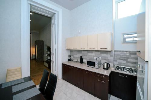 kuchnia z białymi szafkami i blatem w obiekcie Apartment Alexandra w mieście Tbilisi City