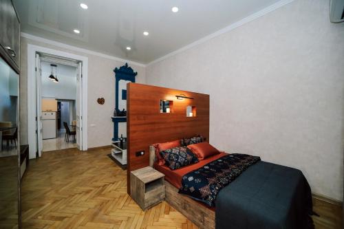 sypialnia z łóżkiem z drewnianym zagłówkiem w obiekcie Apartment Alexandra w mieście Tbilisi City