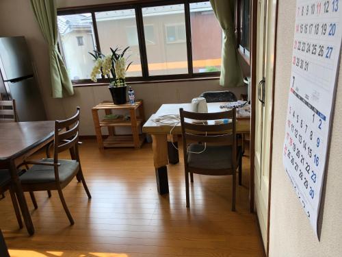 a dining room with a table and chairs and a board at コウノトリの里の宿 in Fukiage