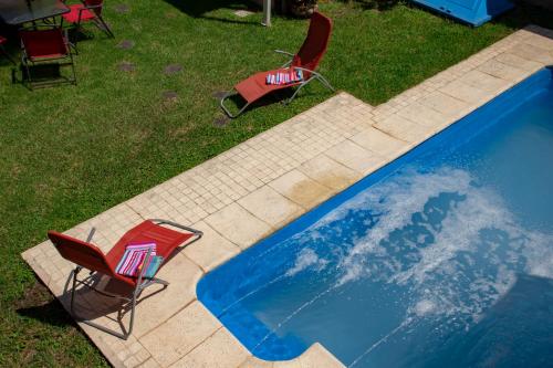 a pair of chairs sitting next to a swimming pool at Caminos Hostal in San Salvador de Jujuy