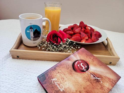 a tray with a cup of coffee and a plate of strawberries at Magic Space Petros Skafias in Shkodër