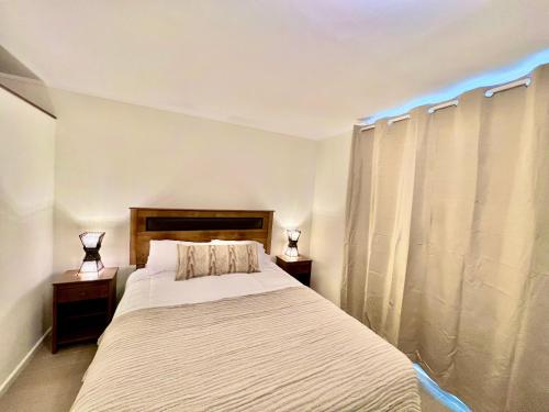 a bedroom with a large bed with two night stands at Departamento Central Ejecutivo- Apart Hotel in Calama