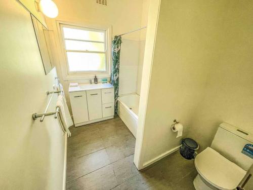 un bagno con un water, un lavandino e una finestra di Mount Beauty 3BR Home a Mount Beauty