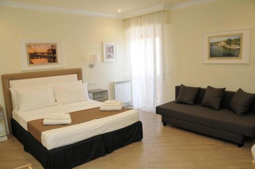 1 dormitorio con 1 cama grande y 1 sofá en MIGDAL Luxury Suites Roma Testaccio en Roma