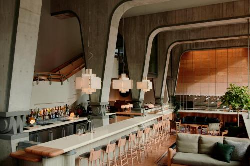 a bar in a restaurant with chairs and a counter at Ace Hotel Toronto in Toronto
