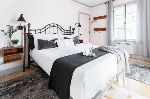 ein Schlafzimmer mit einem großen weißen Bett mit einer schwarzen Decke in der Unterkunft La maison de l'île in Saint-Jean