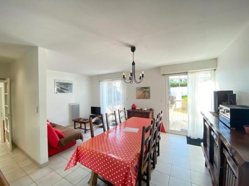- une salle à manger et un salon avec une table et des chaises rouges dans l'établissement Maison rénovée, jardin clos, à 300m de la mer - 6 couchages, WiFi, animaux admis - FR-1-231-205, à Bretignolles-sur-Mer