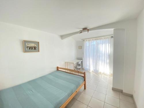une chambre avec un lit, une table et une fenêtre dans l'établissement Maison rénovée, jardin clos, à 300m de la mer - 6 couchages, WiFi, animaux admis - FR-1-231-205, à Bretignolles-sur-Mer