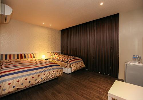 宜蘭市にある羅東愛漫遊の部屋にベッドが2つあるホテルの部屋