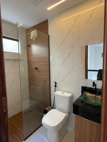 a bathroom with a toilet and a shower and a sink at Flats do Lucca Tamandaré in Tamandaré