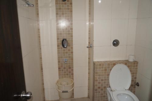 a small bathroom with a toilet and a shower at CENTER POINT in Rudrapur