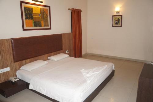 sypialnia z dużym białym łóżkiem w pokoju w obiekcie CENTER POINT w mieście Rudrapur