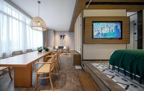 a room with a dining table and a tv on a wall at Shenzhen ALLIN Space to time in Shenzhen