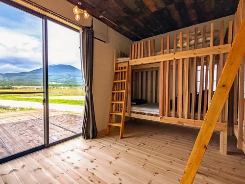 a room with a bunk bed and a large window at Guest House Inawashiro~Hanbog~ in Inawashiro