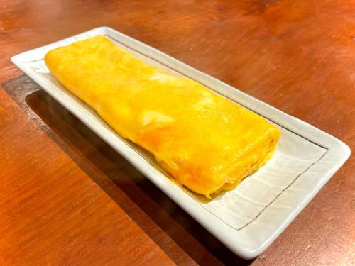 a piece of food sitting on a plate on a table at Guest House Inawashiro~Hanbog~ in Inawashiro