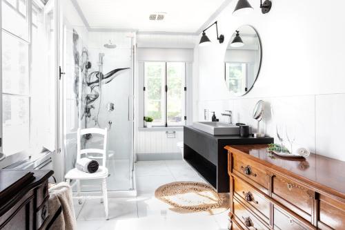 ein Bad mit einem Waschbecken und einem Spiegel in der Unterkunft La maison de l'île in Saint-Jean