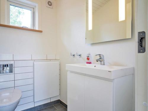 a white bathroom with a sink and a toilet at 6 person holiday home in Aakirkeby-By Traum in Vester Sømarken