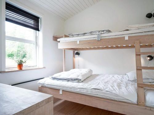 a bedroom with two bunk beds and a window at Holiday home Aakirkeby XXXV in Vester Sømarken