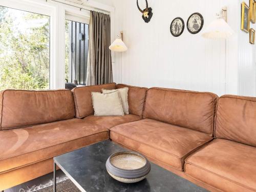 a brown leather couch in a living room with a table at 10 person holiday home in Fjerritslev-By Traum in Fjerritslev
