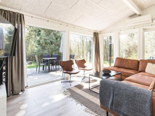 a living room with a couch and a table with chairs at 10 person holiday home in Fjerritslev-By Traum in Fjerritslev