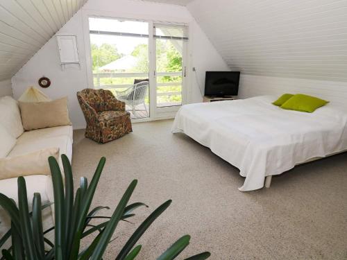 een slaapkamer met een bed, een bank en een televisie bij Holiday home Hadsund CXXXIII in Hadsund