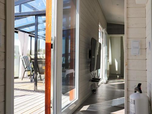 a screened porch with a sliding glass door and a television at Holiday home SÄFFLE IV in Säffle