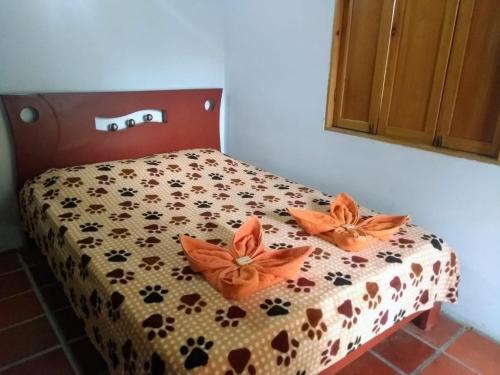 a bed with orange flowers on it in a room at Hotel Ecoturistico Villa Lucy in Curití