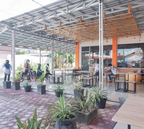 a restaurant with people sitting at tables and plants at Urbanview Hotel Bundaran Besar Palangkaraya by RedDoorz in Palangkaraya