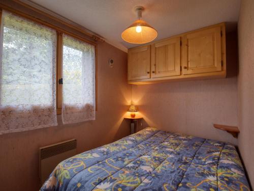 um pequeno quarto com uma cama e uma janela em Appartement Morillon Village, 2 pièces, 4 personnes - FR-1-642-69 em Morillon