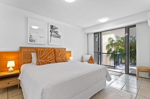 a bedroom with a large bed and a balcony at Seaforth Resort Holiday Apartments in Alexandra Headland