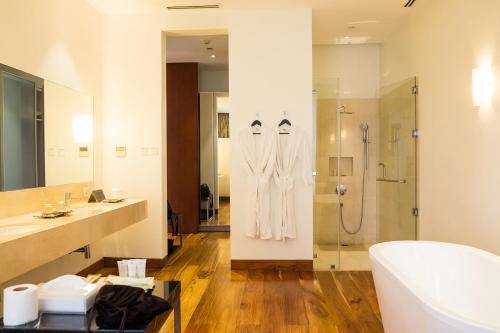 マニラにあるCity Garden Grand Hotelのシャワー、洗面台、浴槽を備えたバスルーム