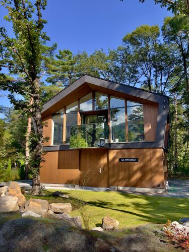 a modern house with large glass windows at Ahiru Chalet by Hakuba White Fox Company in Hakuba