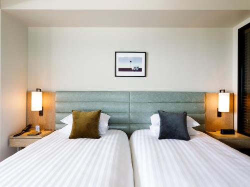 a hotel room with two beds and two lamps at MB GALLERY CHATAN by THE TERRACE HOTELS in Chatan