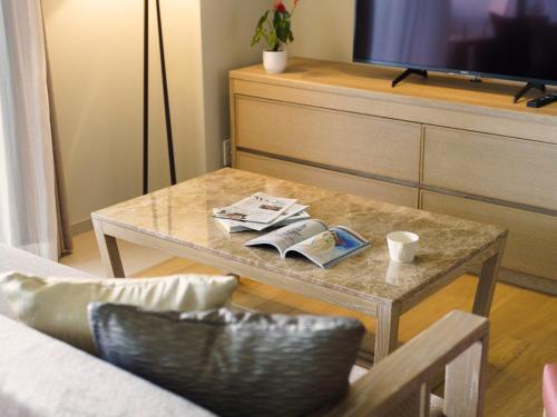 a living room with a coffee table and a tv at MB GALLERY CHATAN by THE TERRACE HOTELS in Chatan