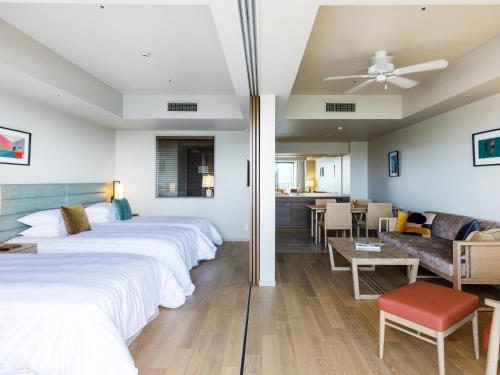 a hotel room with two beds and a living room at MB GALLERY CHATAN by THE TERRACE HOTELS in Chatan