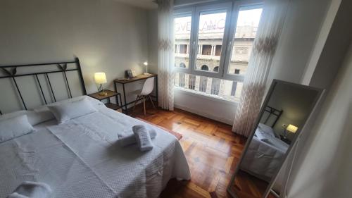 a bedroom with a white bed and a large window at Qhawana Begoña - Pisazo con garaje, Wifi en Begoña - VUT-3633-AS in Gijón