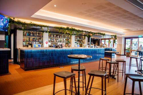 a bar in a restaurant with stools at Bankstown Hotel in Bankstown