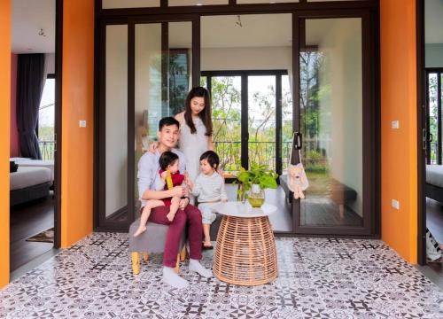 a family posing for a picture in a living room at AKECHI 'S GARDEN - Venuestay in Hòa Bình